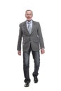 full length picture of a mid aged business man walking towards the camera and smiling. Royalty Free Stock Photo
