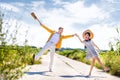 Full length of playful couple on footpath amidst field on sunny day