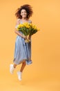 Full-length portrait of African woman jumping with bouquet flo Royalty Free Stock Photo