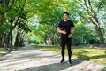 Full length portrait, asian man running in office park, man in sportswear on sunny day, smiling and happy with fitness Royalty Free Stock Photo