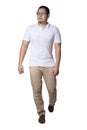 Full length portrait of Asian man wearing white shirt and khaki jeans standing walking, front view Royalty Free Stock Photo