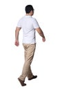 Full length portrait of Asian man wearing white shirt and khaki jeans standing walking, rear view Royalty Free Stock Photo