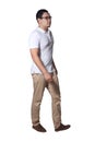 Full length portrait of Asian man wearing white shirt and khaki jeans standing walking, side view profile Royalty Free Stock Photo