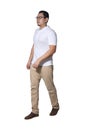 Full length portrait of Asian man wearing white shirt and khaki jeans standing walking, side view profile Royalty Free Stock Photo