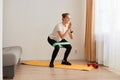 Full length portrait of attractive beautiful charming sporty woman wearing white t shirt and black leggins, doing sit-ups with Royalty Free Stock Photo