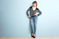 Full length attractive young woman smiling against blue wall Royalty Free Stock Photo
