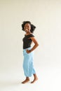 Full length portrait of beautiful african american woman wearing jeans and t-shirt posing on camera with candid smile over white Royalty Free Stock Photo