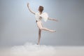 Full-length portrait of beautiful graceful ballerina dancing in image of angel with wings on gray studio
