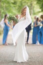 Full length portrait of beautiful sensual young blond bride in long white wedding dress and veil, holding bouquet Royalty Free Stock Photo