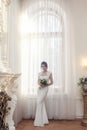 Full-length portrait of the bride near a large window Royalty Free Stock Photo