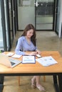 Portrait of businesswoman sitting in modern office and using smart phone. Royalty Free Stock Photo