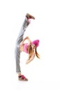 Full-length portrait of carefree girl in gray pants, pink top and hat jumping and dancing. Teen girl hip-hop dancer, over white