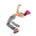 Full-length portrait of carefree girl in gray pants, pink top and hat jumping and dancing. Teen girl hip-hop dancer, over white