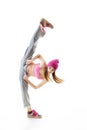 Full-length portrait of carefree girl in gray pants, pink top and hat jumping and dancing. Teen girl hip-hop dancer, over white