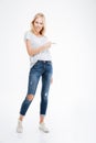 Full length portrait of a casual woman pointing finger away Royalty Free Stock Photo