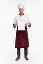 Full length portrait of a cheerful male chef cook in uniform holding blank board isolated on a white background. Royalty Free Stock Photo