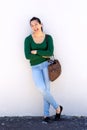 Full length portrait of cheerful asian woman standing with purse Royalty Free Stock Photo