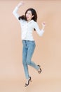 Full length portrait of cheerful positive pretty businesswoman jumping in the air with raised fists isolated on orange background Royalty Free Stock Photo