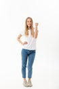 Full-length Portrait of a cheerful woman in white shirt and jean celebrating her success over white background Royalty Free Stock Photo