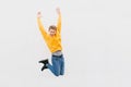 Full length portrait of a cheerful young man in white t-shirt pointing fingers away while celebrating success isolated over red Royalty Free Stock Photo