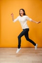 Full length portrait of a cheerful young woman jumping Royalty Free Stock Photo