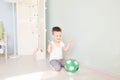 Full length portrait of a child with a soccer ball in home