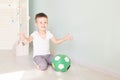Full length portrait of a child with a soccer ball isolated in home