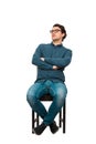 Full length portrait of confident businessman seated relaxed on a chair, wearing eyeglasses and keeps arms crossed, isolated on Royalty Free Stock Photo