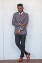 Full length portrait of confident handsome african business man posing in modern grey suit against a gray concrete wall Royalty Free Stock Photo