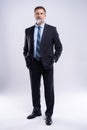 Full length portrait of confident mature businessman in formals standing isolated over white background. Royalty Free Stock Photo