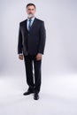 Full length portrait of confident mature businessman in formals standing isolated over white background. Royalty Free Stock Photo