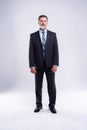 Full length portrait of confident mature businessman in formals standing isolated over white background. Royalty Free Stock Photo