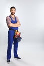 Full length portrait of construction worker with tool belt on light background Royalty Free Stock Photo