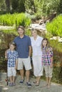 Full length portrait of couple with children standing against lake Royalty Free Stock Photo