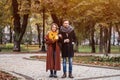 Full length portrait of a couple on a date walking in the autumn park holding hands. Outdoor shot of a young couple in Royalty Free Stock Photo
