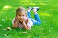 Full length portrait of  cute little smiling girl with pigtails lying on the green grass in park Royalty Free Stock Photo