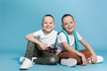 Full length portrait of cute twin brothers sitting Royalty Free Stock Photo