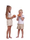 Kids eating pastry isolated on a white background. Cute brother and sister eating cinnamon buns. Homemade pastry concept Royalty Free Stock Photo