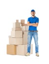 Full length portrait of delivery man standing near stack of boxes