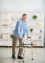 Full length portrait of elderly man walking with frame at retirement home. Limited excursion in elderly people Royalty Free Stock Photo