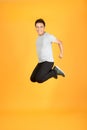 Full length portrait of an excited Asian man jumping over orange background Royalty Free Stock Photo