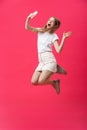 Full length portrait of an excited teenage schoolgirl in uniform with taking a selfie while jumping and showing say hi Royalty Free Stock Photo