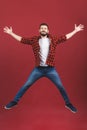 Full length portrait of an excited young man in casual jumping while celebrating success isolated over red background Royalty Free Stock Photo