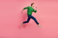 Full length portrait of excited young man in shirt jumping fast running isolated over pastel color background Royalty Free Stock Photo