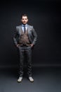 Full length portrait of a fashion male model over black background. Looking at camera. Royalty Free Stock Photo