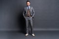 Full length portrait of a fashion male model over grey background. Looking at camera. Royalty Free Stock Photo