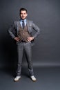 Full length portrait of a fashion male model over grey background. Looking at camera. Royalty Free Stock Photo