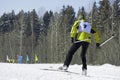 Full length portrait of a female skier standing with one leg raised on a ski slope on a Sunny day against a ski lift. Winter vacat Royalty Free Stock Photo