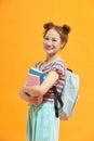 Full length portrait of a female student with a backpack and books isolated on yellow background Royalty Free Stock Photo