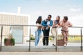 Full length portrait of four teenage real students smiling and talking together at university campus. Group of young Royalty Free Stock Photo